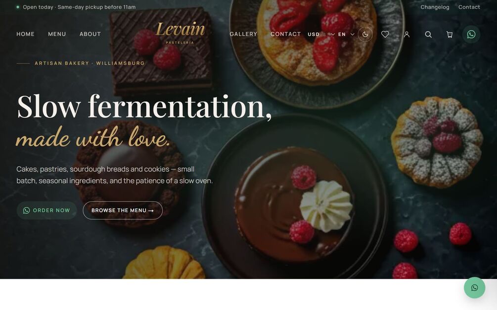 The Levain home page in the Dark and Moody theme: the headline Slow fermentation made with love over an overhead spread of cakes and pastries, with an Order Now WhatsApp button next to Browse the Menu, above a utility nav carrying currency, language, theme, wishlist, account, search, cart and WhatsApp.