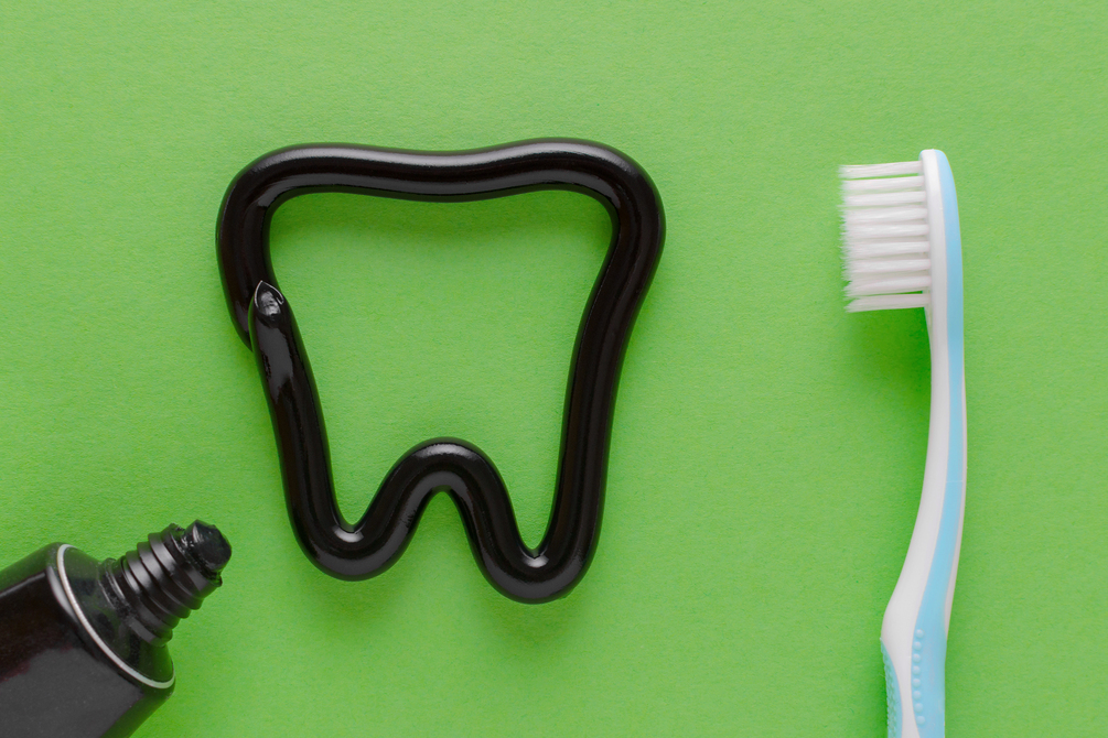 Photo "a tooth from black toothpaste, teeth care concept, toothbrush on