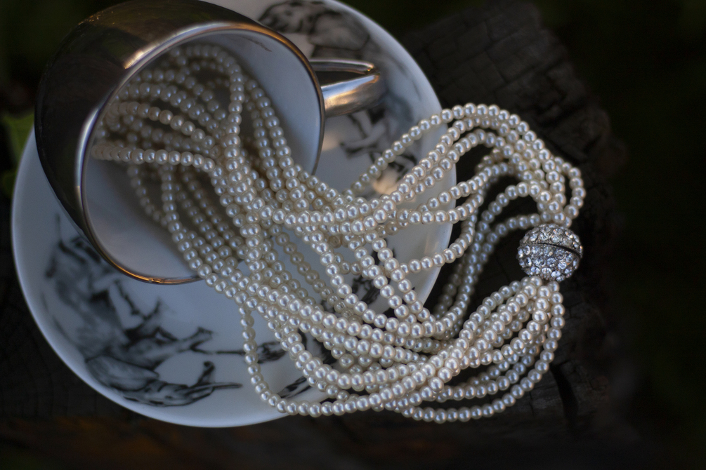 Pearl necklace and earring set in teacup photographs
